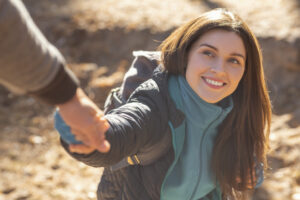 portrait of happy young woman outstretching hand to man