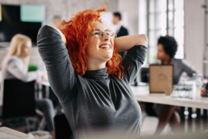 young happy businesswoman relaxing in the office with hand behind head.